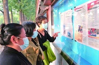 北京市民在北海公园阅报栏阅览党的二十大有关报道